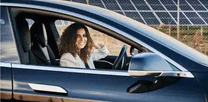 Electric car next to solar panels plant