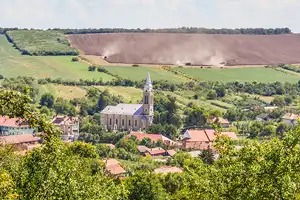 Salaj chargers Small town with a church in the center and agricultural fields in the background.