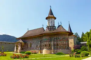 Suceaca chargers Orthodox church on a green field in a sunny day.