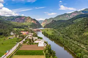 Valcea chargers Aeral view of a river with green hills.